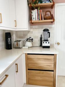 a kitchen with white cabinets and a blender on a counter at Cosy 3 bedroom home, 2 minutes from the beach in Perranporth