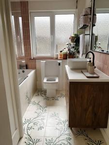 a bathroom with a toilet and a tub and a sink at Cosy 3 bedroom home, 2 minutes from the beach in Perranporth +12 photos