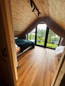a room with a bed and a large window at Ostoya Zawory -domki premium ,strefa relaksu, basen in Zawory +50 photos
