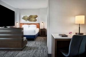 a hotel room with a bed and a desk with a computer at Hilton Fairfax, Va in Fairfax