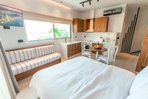 a bedroom with a bed and a table and a kitchen at Granny's House in Kos Town
