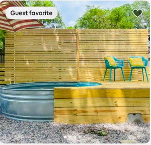 a hot tub in front of a wooden fence with a chair at The Hickory House with Firepit- Boat Ramp Access to Cedar Creek Lake in Tool