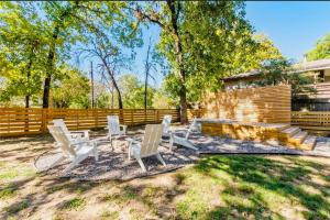 a yard with white chairs and a wooden fence at The Hickory House with Firepit- Boat Ramp Access to Cedar Creek Lake in Tool
