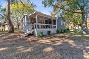 a small blue house with a porch and trees at The Hickory House with Firepit- Boat Ramp Access to Cedar Creek Lake in Tool