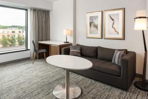 a living room with a couch and a table at Hilton Fairfax, Va in Fairfax