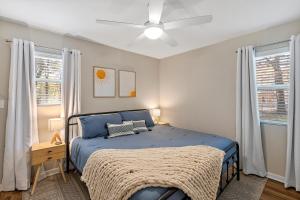a bedroom with a blue bed and two windows at The Hickory House with Firepit- Boat Ramp Access to Cedar Creek Lake in Tool