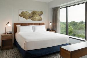 a bedroom with a large bed and a large window at Hilton Fairfax, Va in Fairfax
