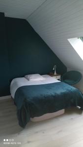 a bedroom with a large bed with a green wall at Leroi in Fay +1 photo