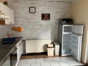 kuchnia z lodówką i zegarem na ścianie w obiekcie Ferienwohnung Haus Cerny w mieście Bad Goisern