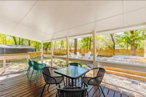 a patio with a table and chairs on a deck at The Hickory House with Firepit- Boat Ramp Access to Cedar Creek Lake in Tool