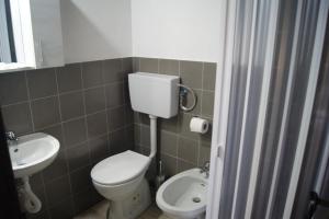 a small bathroom with a toilet and a sink at Abbamala Village in Bosa +42 photos