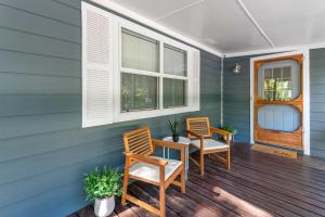 two chairs and a table on the front porch of a house at The Hickory House with Firepit- Boat Ramp Access to Cedar Creek Lake in Tool