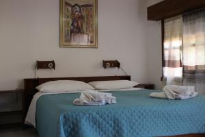 two beds in a bedroom with towels on them at Abbamala Village in Bosa