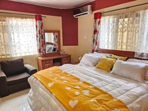 a bedroom with a large bed and a chair at MacCarthy Residence in Accra