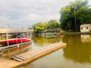 a boat is docked at a dock on a river at The Hickory House with Firepit- Boat Ramp Access to Cedar Creek Lake in Tool