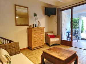 a living room with a dresser and a table at Joli appartement entier sur jardin avec salle d'eau et chambre indépendantes et cuisine équipée in Marigot