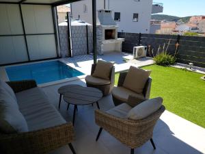 トロギールにあるUNIQUE Trogir - garden with PRIVATE heated massage POOL ONLY FOR YOUの椅子とプールのあるパティオ