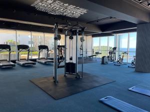 ein Fitnessstudio mit mehreren Laufbändern und Ergometern in der Unterkunft Lucero - Beach Condo in Mazatlán