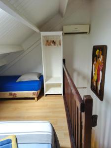 a small room with a bed and a staircase at Joli appartement entier sur jardin avec salle d'eau et chambre indépendantes et cuisine équipée in Marigot