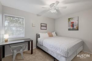 a bedroom with a bed and a desk and a ceiling fan at 2 Miles to DT Updated Pet-Friendly Home for Four in Austin
