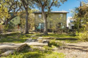a green house with trees in the yard at 2 Miles to DT Updated Pet-Friendly Home for Four in Austin
