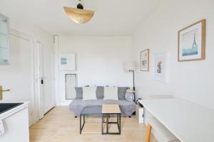 a white bedroom with a bed and a table at Appartement Cosy and Quiet Paris Villette in Le Pré-Saint-Gervais +22 photos