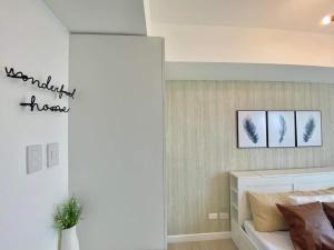 a bedroom with a bed with three pictures on the wall at Modern & Minimalist Space Azure North Residences in San Fernando