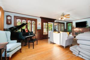a living room with a piano and white furniture at Lake Michigan Retreat- Upper Duplex in Benton Harbor