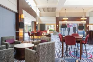 a hotel lobby with chairs and tables and a bar at Hilton Fairfax, Va in Fairfax