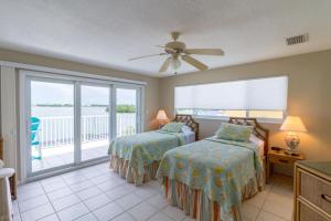 a bedroom with two beds and a balcony at Manatee Bay in Key Colony Beach +42 photos