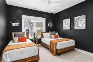 two beds in a room with black walls at Patio FirePit Garage Walk to Coffee Restaurants 12 South and Belmont in Nashville