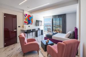 a hotel room with a bed and two chairs at Vip penthouse patra in Patra