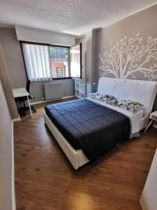 a bedroom with a large bed with a tree mural on the wall at Lake&Stars - Il lago e le stelle in Ispra