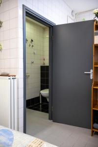 a bathroom with a door leading to a toilet at Voormalige Gevangenis Cel bij B&B Gezond aan Zee - Toegang Wellnesstuin meerprijs in Ouddorp