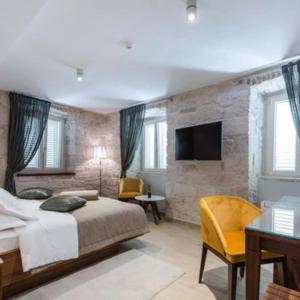 sypialnia z łóżkiem, biurkiem i telewizorem w obiekcie Heritage hotel Viganj w Orebiciu +90 zdjęć