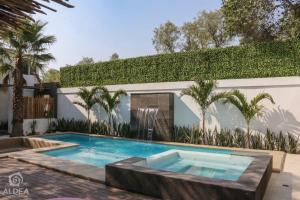 a swimming pool in the backyard of a house at ALDEA Luxury villas & suites in San Martín de las Pirámides