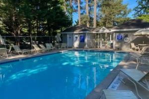 a swimming pool with chairs and a house at Westwood --- 828 Westwood Unit D in Bethany Beach