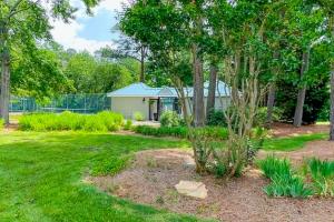 a yard with a house in the background with trees at Westwood --- 828 Westwood Unit D in Bethany Beach