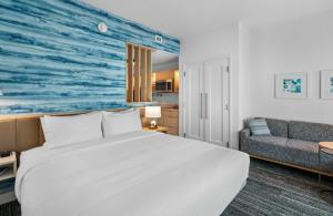 una camera da letto con un grande letto bianco e un divano di TownePlace Suites Jacksonville Airport a Jacksonville Altre 107 foto