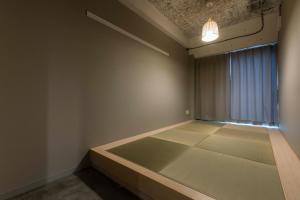 
a room with a bed, a lamp, and a window at Imano Tokyo Hostel in Tokyo
