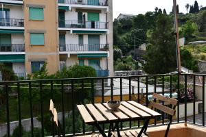 a wooden table on a balcony with a building at Ca' Da Marghe - San Terenzo in San Terenzo
