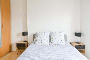 a bedroom with a bed with two lamps on tables at Appartement Cosy and Quiet Paris Villette in Le Pré-Saint-Gervais