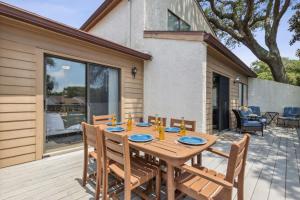 a wooden table with four chairs on a deck at 2625 Forest Ridge - Pool - Tennis - Pickleball - Large Deck in Fernandina Beach