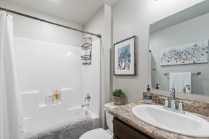 a white bathroom with a sink and a toilet at Destiny Cove in Kalispell +17 photos