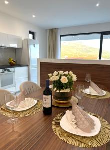 tavolo da pranzo con 2 piatti e una bottiglia di vino di Villa Apartment Danny a Baška Voda