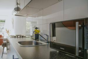 a kitchen with a sink and a microwave at Luxe studiomuseumgebiedEftelingUvT in Tilburg +15 photos