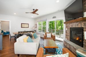 a living room with a white couch and a fireplace at Townsend Gem: Retreat with Hot Tub & Fire Pit in Townsend