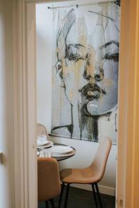 une chambre avec une table et une peinture d'une femme dans l'établissement Centraal Apt In Centrum A Locatie Begane Grond, à Tilbourg