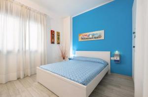 a bedroom with a bed with a blue wall at Casa Celeste in Calasetta