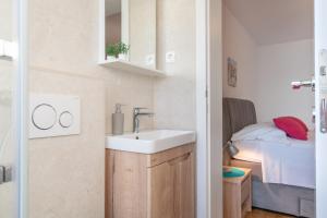a bathroom with a sink and a bed at Apartments Malina in Tučepi +63 photos